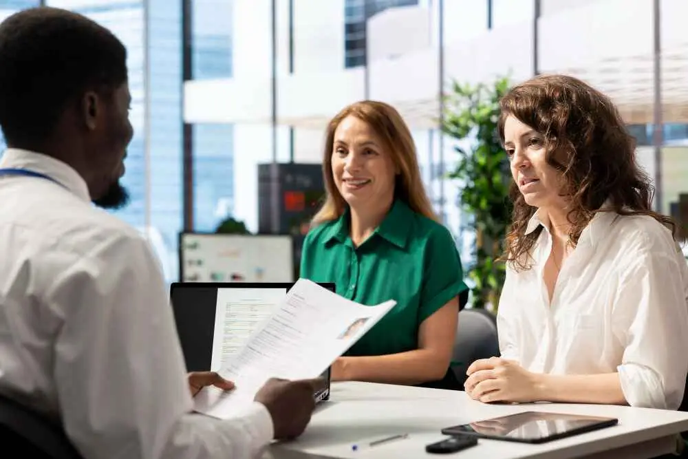 A recruitment agency team meeting with a man and two women in a modern city centre office