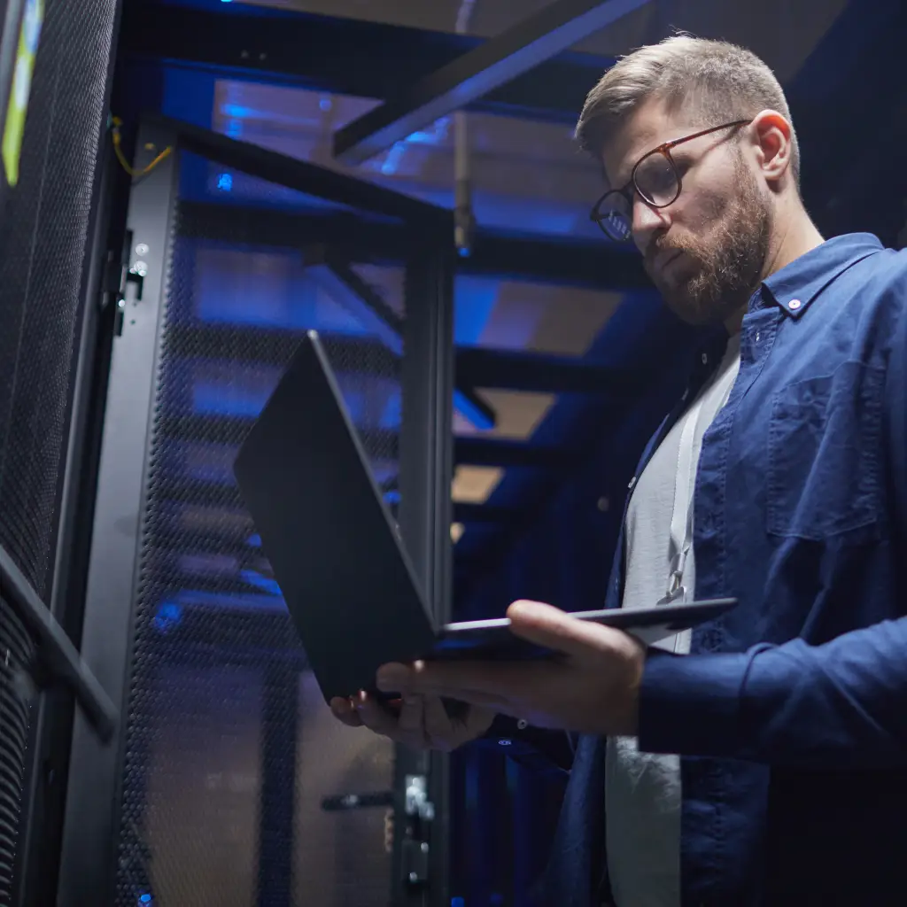 A Nuerofy data engineer in a data centre holding a lap top